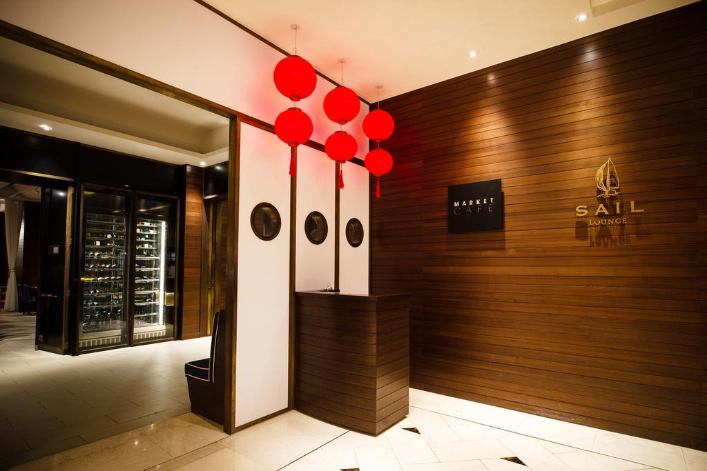 Ambassador Hotel Kaohsiung Exterior foto The photo shows the interior of a restaurant or establishment named "SAIL." The entrance features a wooden wall with a logo displayed prominently. There are decorative red lanterns hanging above the reception area, which has a sleek, modern design. O