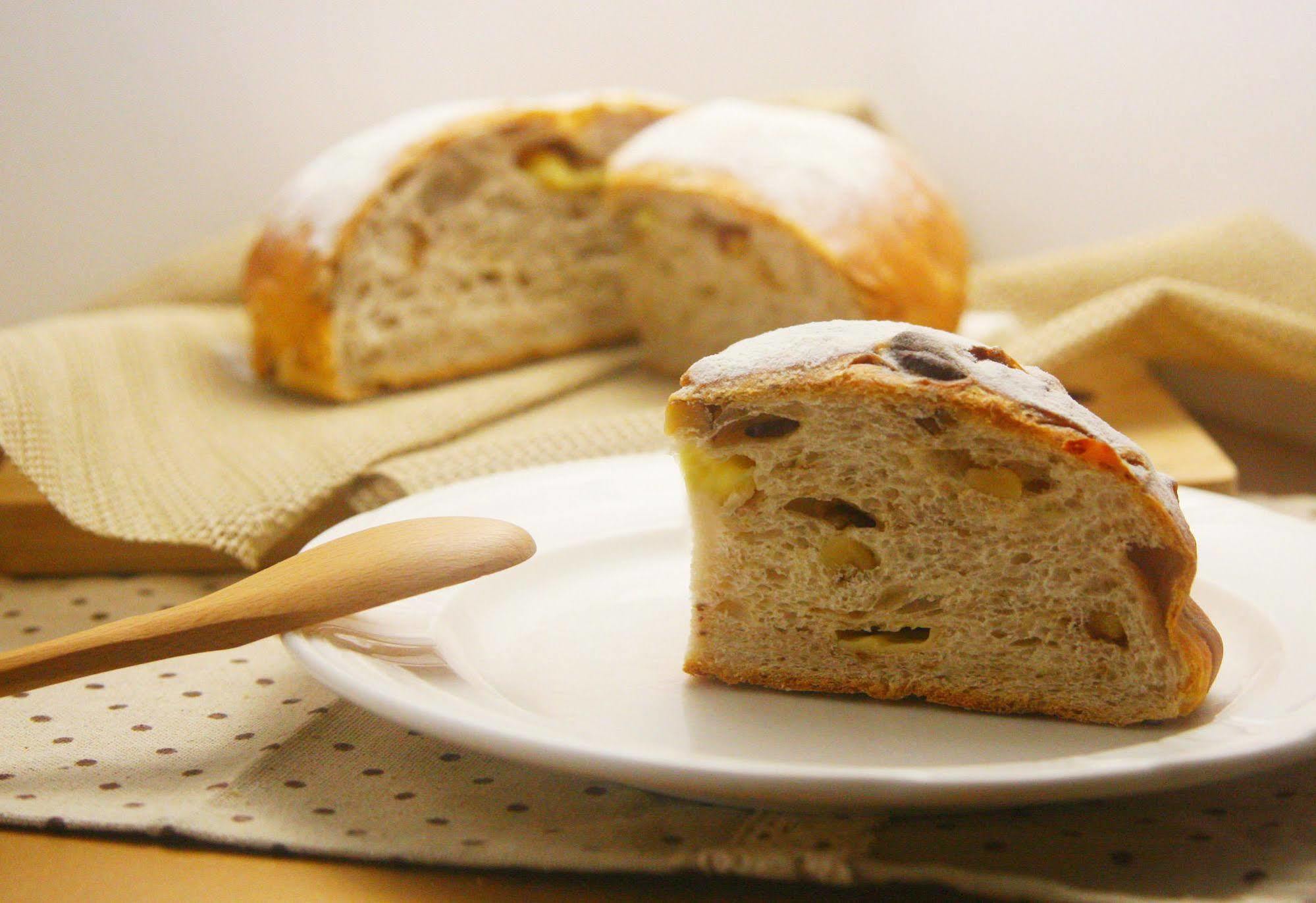 Ambassador Hotel Kaohsiung Exterior foto The photo shows a slice of bread placed on a white plate, revealing its soft, textured interior and bits of dried fruit or nuts within. In the background, there’s a whole round loaf of the same bread, which appears golden and slightly shiny on the cr